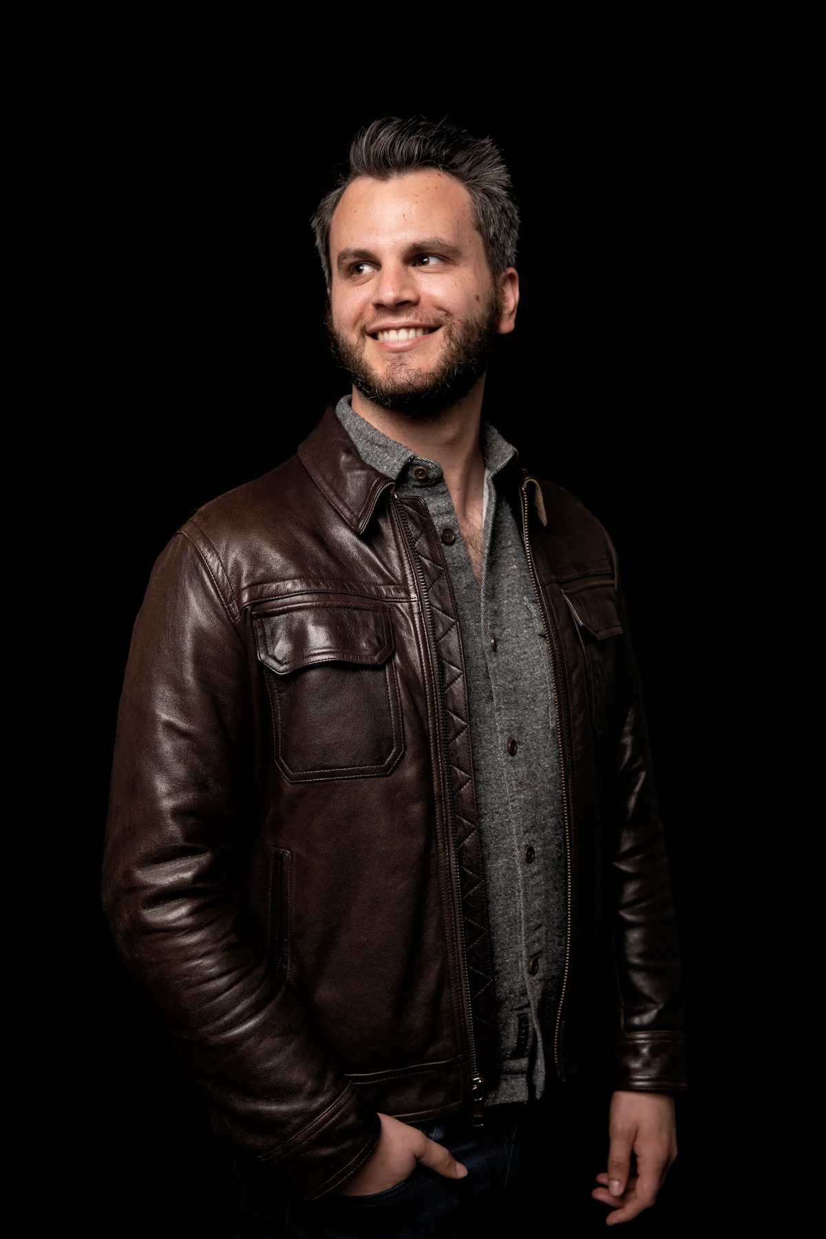 Alex Boyd, in a brown leather jacket, looking off to one side.
